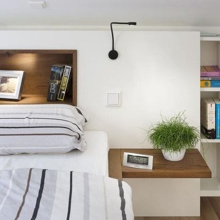 Bett mit Nachtschränkchen in weiß und Holzelementen